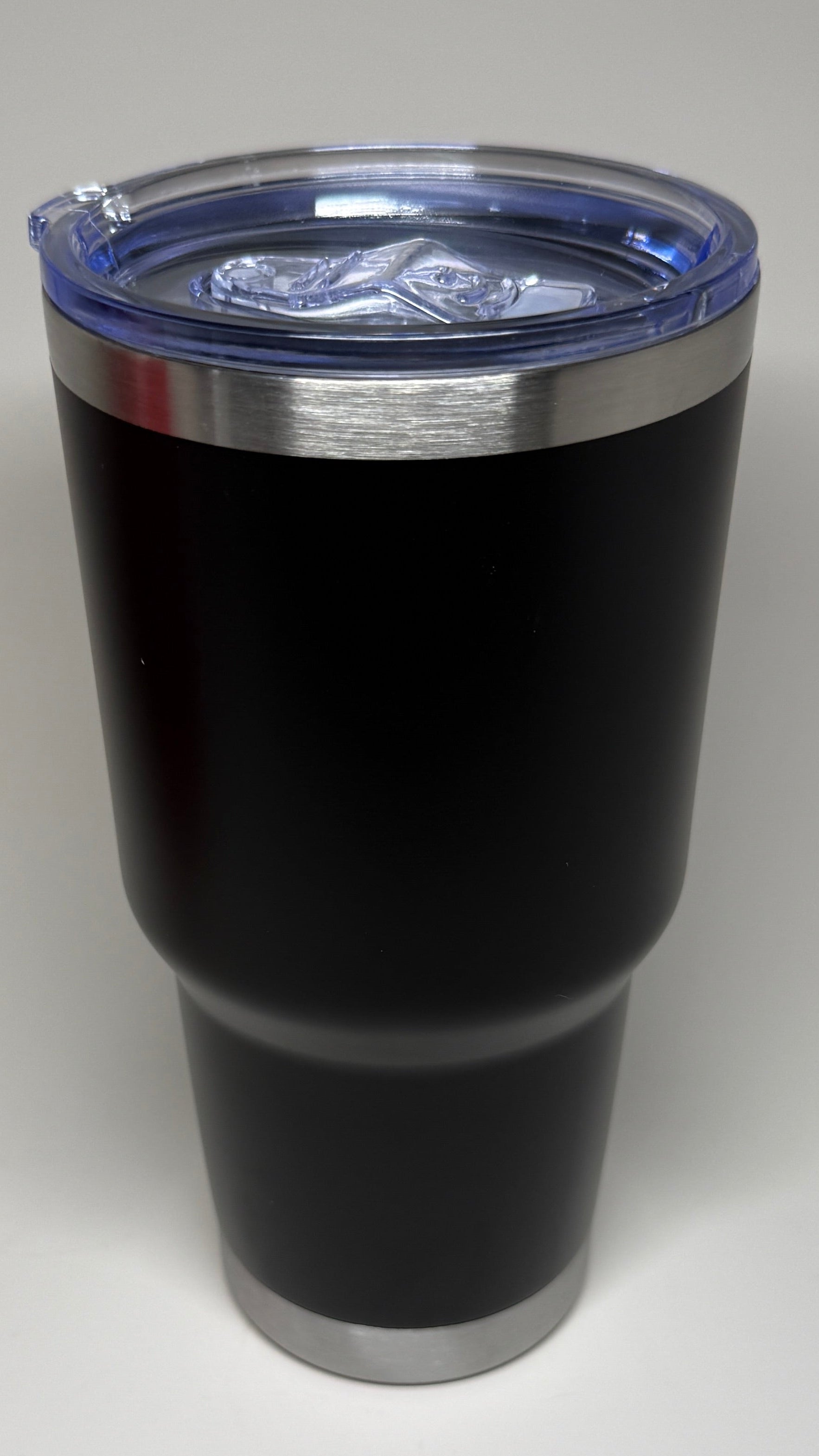 Black tumbler with a silver rim on a white background